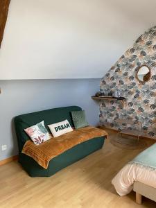 a room with a couch with pillows on it at Entre terre et baie à 15 mn du Mont-Saint-Michel in Pontaubault +37 photos