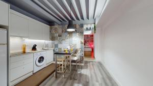 a kitchen with white cabinets and a washer and dryer at Myflats Old Corner in Alicante