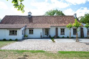 a white house with a tile roof at House on the Green in Waregem
