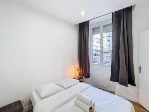 een slaapkamer met twee bedden en een raam bij My Home Saint Jérome 2 in Lyon