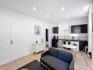 een woonkamer met een bank en een tafel bij My Home Saint Jérome 2 in Lyon +4 foto's