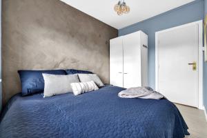 a bedroom with a blue bed and a wall at Classic Super central - Balcony - 6 pers in Oslo