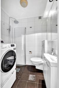 a bathroom with a washing machine and a sink at Classic Super central - Balcony - 6 pers in Oslo +20 photos