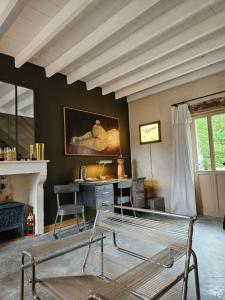 a room with a bed and a desk and a painting at Villa RABADA in Rosnay