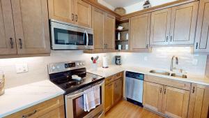 a kitchen with wooden cabinets and a stove top oven at Beautiful Sunrise in Folly Beach +22 photos