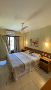 a bedroom with a bed and a ceiling fan at Apartamento Encantador Térreo Piscina B04 in Rio do Fogo