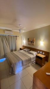 a bedroom with a bed and a ceiling fan at Apartamento Encantador Térreo Piscina B04 in Rio do Fogo +39 photos