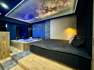 a bedroom with a bed and a bathtub and a window at Kostecki Exclusive Apartments & Spa in Katowice
