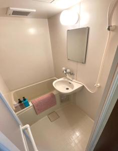 a small bathroom with a sink and a mirror at #3 新宿まで2分! 清潔で安全な部屋! WiFi無料! in Tokyo