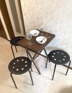 a wooden table and two chairs with wine glasses at #3 新宿まで2分! 清潔で安全な部屋! WiFi無料! in Tokyo