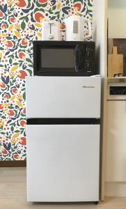 a microwave on top of a refrigerator in a kitchen at #3 新宿まで2分! 清潔で安全な部屋! WiFi無料! in Tokyo