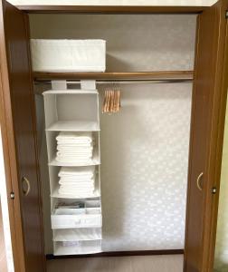a closet with a door full of towels at #3 新宿まで2分! 清潔で安全な部屋! WiFi無料! in Tokyo