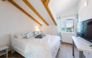 a bedroom with a bed and a desk and a television at 3 Bedroom Stunning Home In Tkon in Tkon