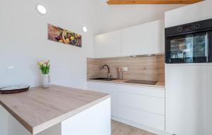 a kitchen with white cabinets and a wooden counter top at 3 Bedroom Stunning Home In Tkon in Tkon