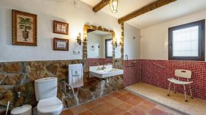 a bathroom with a toilet and a sink at Spacious villa with mountain view and pool in Baza in Baza
