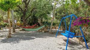 a hammock in a park with trees and flowers at Spacious villa with mountain view and pool in Baza in Baza