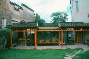 un padiglione in legno nel cortile di un edificio di Standing in the wild a Xiwu