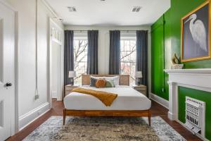 Un dormitorio con una cama con una pared verde. en Jazz Haven Spacious 3BR Condo, en Nueva Orleans