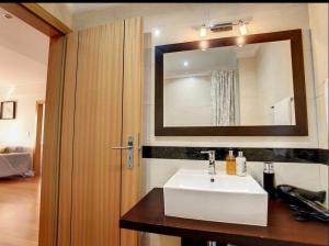 a bathroom with a white sink and a mirror at VeBella Abegoaria in Caniço +16 photos