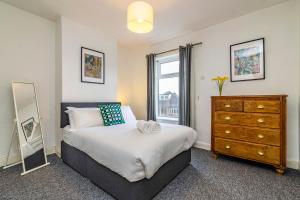 a bedroom with a bed and a dresser and a window at Beeston town house - Sleeps 4 in Beeston