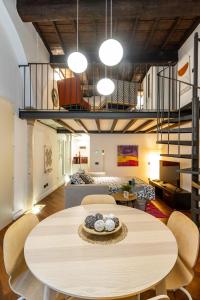 a room with a table and chairs and a living room at Coccole in Ferrara Centro - Luxury Loft in Ferrara
