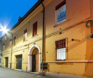 a yellow building with a door and a window at Coccole in Ferrara Centro - Luxury Loft in Ferrara