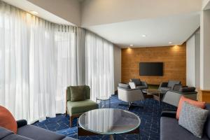 a living room with a couch and chairs and a tv at Courtyard by Marriott Atlanta Northlake in Atlanta