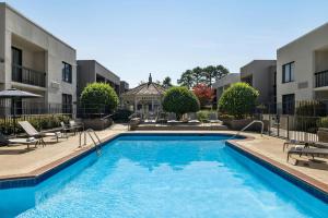 a swimming pool with chairs and a building at Courtyard by Marriott Atlanta Northlake in Atlanta