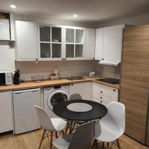 a kitchen with white cabinets and a table and chairs at Center Marina view Purple Studio in Funchal