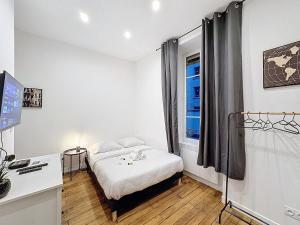 een kleine slaapkamer met een bed en een raam bij My Home Saint Jérôme 1 in Lyon