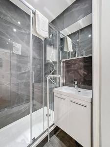 een witte badkamer met douche en wastafel bij My Home Saint Jérôme 1 in Lyon