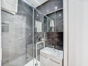 een witte badkamer met douche en wastafel bij My Home Saint Jérôme 1 in Lyon