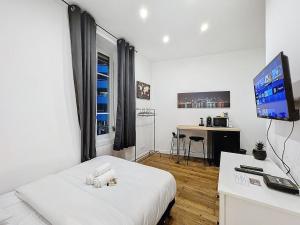 een witte kamer met een bed en een televisie bij My Home Saint Jérôme 1 in Lyon