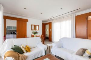 Una sala de estar con un sofá blanco y una cocina. en Casa particular en la playa a pocos metros del mar con garaje, en Playa de Miramar