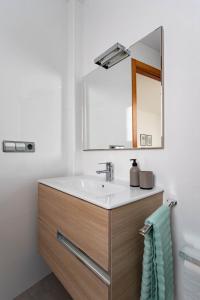 un baño con lavabo y espejo en Casa particular en la playa a pocos metros del mar con garaje, en Playa de Miramar