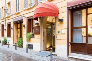 a building with a red awning on a street at Phi Hotel Bologna in Bologna