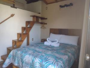 a bedroom with a bed with a towel animal on it at Aldea Xochi cabañas in Chiconcuac