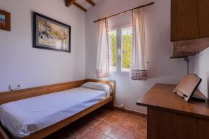a small bedroom with a bed and a window at Villa Silvina - Close to the Beach in Son Bou +14 photos