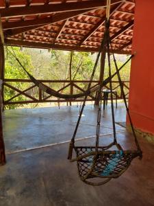 an empty swing hanging from a roof at Aldeia Raizama - Casa Copa in Alto Paraíso de Goiás +7 photos