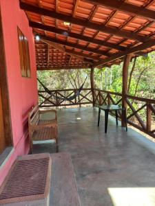 a porch with benches and a wooden roof at Aldeia Raizama - Casa Copa in Alto Paraíso de Goiás