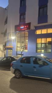 a blue car driving down a street in front of a building at Casa Andalucia in Chefchaouene