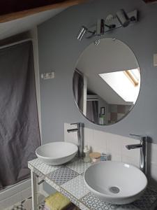 Un baño con dos lavabos y un espejo. en Maison de pierre entre golfe et Océan, en Sarzeau