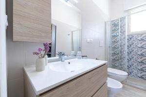 a white bathroom with a sink and a toilet at Punta Prosciutto Bed in Torre Lapillo +42 photos