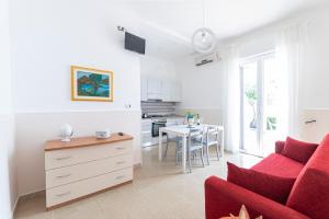 a living room with a red couch and a table at Punta Prosciutto Bed in Torre Lapillo