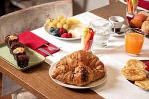 a table with plates of pastries and fruit on it at Phi Hotel Bologna in Bologna