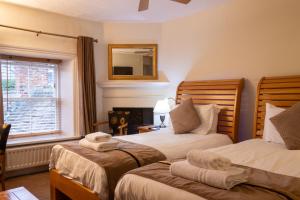 a bedroom with two beds and a mirror on the wall at The Frenchgate Bed and Breakfast in Richmond