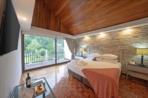 塞罗蓬塔Hotel Bambito By Faranda Boutique, a member of Radisson Individuals的一间卧室设有一张大床和砖墙
