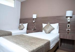 a hotel room with two beds and two lamps at Betania Hotel in Santa Marta