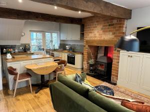 a kitchen and living room with a couch and a table at The Cottage, Upper Linney, Ludlow in Ludlow
