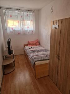 une petite chambre avec un lit et une fenêtre dans l'établissement Komfort Wohnung zur Alleinnutzung, à Mengkofen